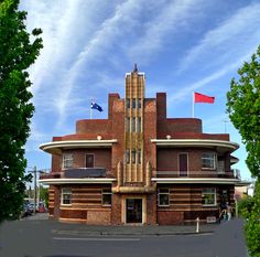 an old brick building with two flags on top