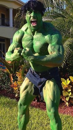 a man dressed as the incredible hulk in front of a house