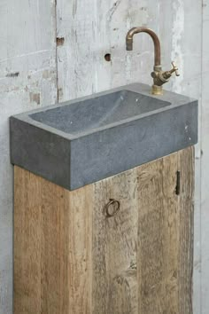 a sink made out of wood and concrete with a faucet on the side