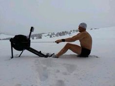 a man sitting in the snow with skis attached to his feet, pulling a sled behind him