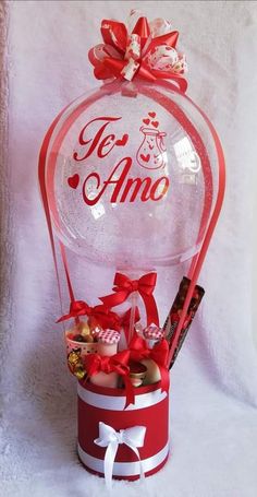 a red and white basket filled with lots of candy next to a sign that says tea amo