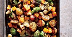 roasted veggies and potatoes with herbs on a baking sheet, ready to be eaten