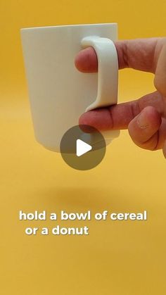 a hand holding a white coffee cup with the words hold a bowl of cereal or a donut