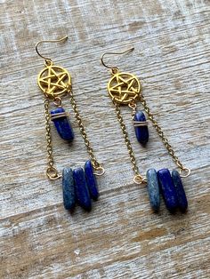 Handmade with gold tone chain and charms, and lazurite stones. Measures about 3.25 inches tall Symbolic Brass Dangle Jewelry, Gold Lapis Lazuli Pierced Jewelry, Gold Lapis Lazuli Jewelry, Mystical Brass Dangle Jewelry, Blue Brass Dangle Jewelry, Mystical Wire Wrapped Dangle Jewelry, Wire Wrapped Lapis Lazuli Dangle Earrings, Lapis Lazuli Dangle Jewelry, Brass Jewelry With Dangling Charms