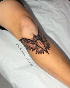 a woman laying on top of a bed with a tattoo on her arm and leg