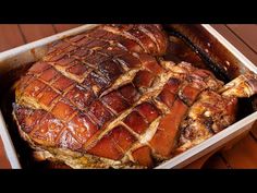 a roasting pan filled with meat on top of a wooden table