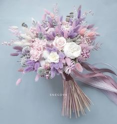 a bridal bouquet with pink and white flowers on a blue background is featured in this image