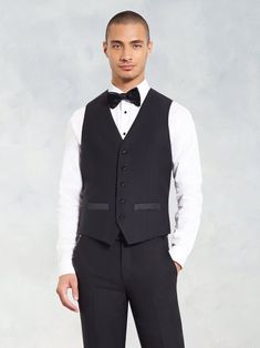 Designed to be worn with any of our black tuxedos, this vest has you covered - from layered under a jacket, to boogie-ing without one on the dance floor. 100% super-fine Italian merino wool Five-button closure Full backing Black satin accents Elegant Winter Vest, Fitted Black Three-piece Suit For Winter, Tuxedo Style Business Vest Sleeveless, Sleeveless Tuxedo Vest For Business, Formal Winter Sleeveless Vest, Formal Sleeveless Winter Vest, Winter Black Tie Tuxedo Suits, Tailored Sleeveless Blazer For Parties, Sleeveless Tailored Party Blazer