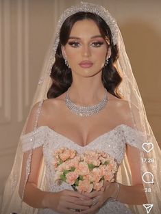 a woman in a wedding dress holding a bouquet of flowers and wearing a tiara