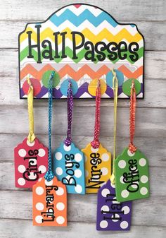 colorful luggage tags hanging on a wall with the word hall passes written in large letters