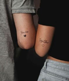 two people with matching tattoos on their arms, one has the word together and the other has