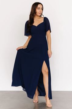 a woman wearing a blue dress with a slit down the side and one leg up