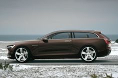 a brown car parked on the side of a snowy road next to the ocean in front of an overcast sky