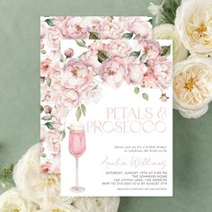 a pink wine glass and flowers are on top of the floral wedding shower party card