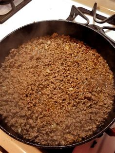 a frying pan filled with food on top of a stovetop next to a burner