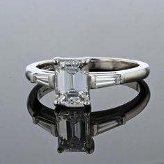 an emerald cut diamond ring with baguettes on the sides and tapered shoulders