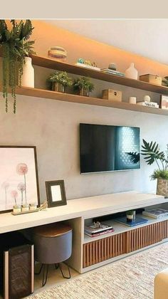 a flat screen tv sitting on top of a wooden shelf in a living room next to a window