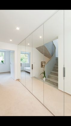 an empty room with mirrored walls and stairs in the center, as well as a potted plant