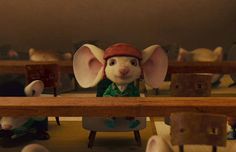 a mouse sitting on top of a wooden bench in front of other stuffed animals and mice