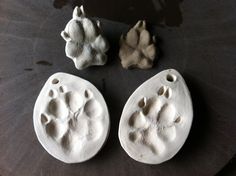 three ceramic animal paw prints sitting on top of a table