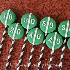 six green and white golf balls with black and white striped straws in the shape of numbers