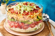 a large salad in a glass bowl on top of a table