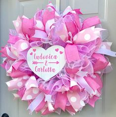 a pink and white heart wreath with polka dots on the front door for someone's wedding