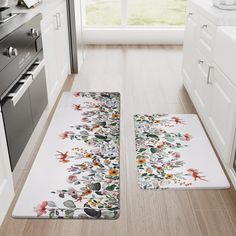 two kitchen mats with flowers on them in the middle of a floor next to an oven