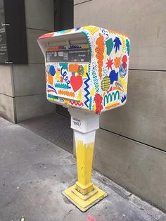 a brightly painted mailbox sitting on the side of a building