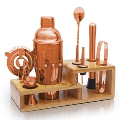 an assortment of copper colored metal objects on wooden trays and stands, including a cocktail shaker