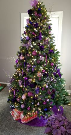 a decorated christmas tree with purple and silver ornaments