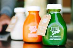 three juice bottles sitting on top of a table