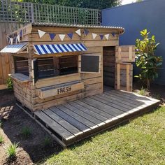 a small food stand made out of pallets and wooden planks in the yard