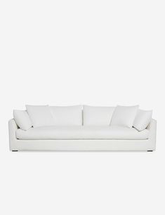 a white couch with four pillows on it