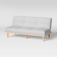 a white couch sitting on top of a wooden frame