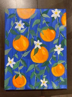 an acrylic painting of oranges and flowers on a blue background