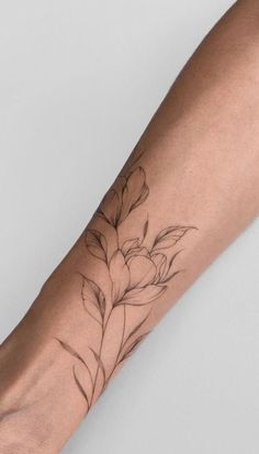 a woman's arm with a flower tattoo on it