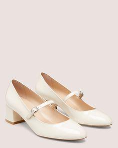 a pair of white shoes with buckles