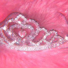 the heart shaped brooch is on top of pink fur and has diamonds in it