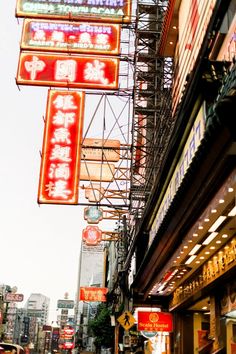 a city street with many signs hanging from the side of buildings