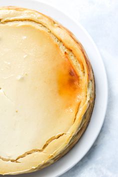 a cheese pie on a white plate sitting on a table