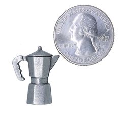 a silver coffee pot next to a quarter dollar