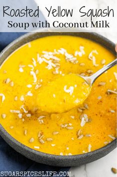 a spoonful of roasted yellow squash soup with coconut milk in a gray bowl on a marble counter