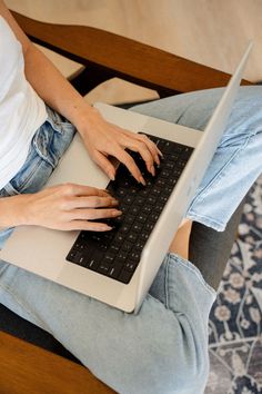 a woman is typing on her laptop computer