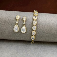 This gold teardrop bridal earrings and bracelet set features sparkling zirconia teardrops that shine beautifully. Designed for brides and bridesmaids, this gift set includes elegant crystal earrings and a matching bracelet, perfect for adding a touch of glamour to any wedding ensemble. Made with high-quality materials, all pieces are nickel-free for comfort and durability. Ideal for brides, bridesmaids, or as a thoughtful gift for the maid of honor. CZ EARRINGS: 💖  Earring Length about: 1.38 in Earrings For Bride, Teardrop Bridal Earrings, Bridesmaids Gift Sets, Wedding Jewelry Set, Cz Bracelet, Gold Wedding Jewelry, Matching Bracelet, Cz Earrings, Brides And Bridesmaids