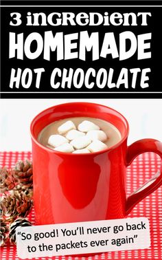 a red mug filled with hot chocolate and marshmallows on top of a table