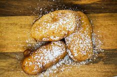 powdered sugar covered doughnuts piled on top of each other