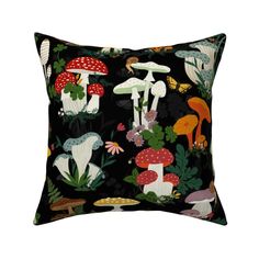 a black pillow with mushrooms and plants on the front, along with other green leaves