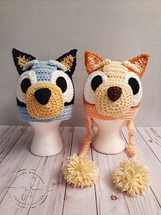 two crocheted animal hats on top of white mannequins, one with black eyes and the other with brown nose