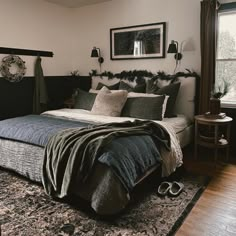 a bedroom with a bed, rug and two lamps on the side of the room